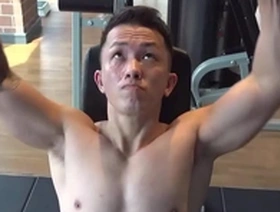 A handsome Asian man getting fit in the gym before a nipple play session.